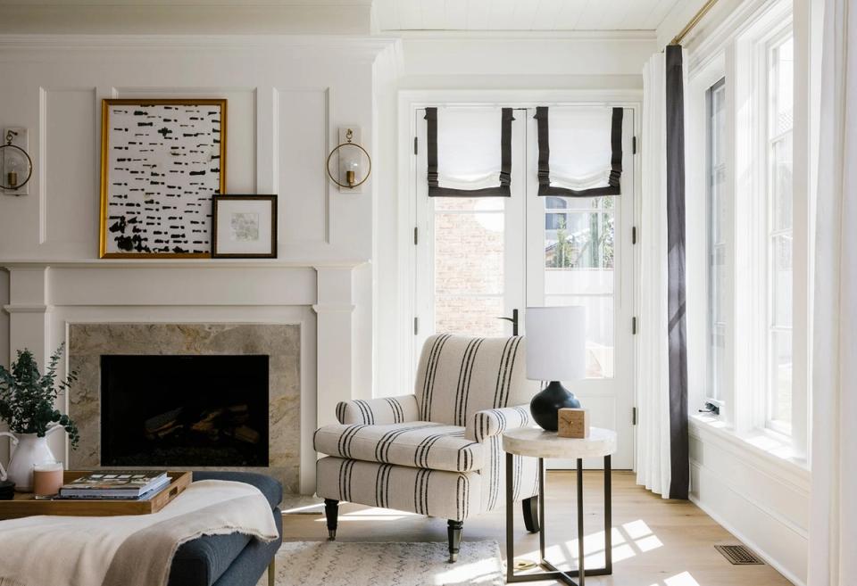 Classic transitional living room with striped accent chair, fireplace, and black-trimmed French doors