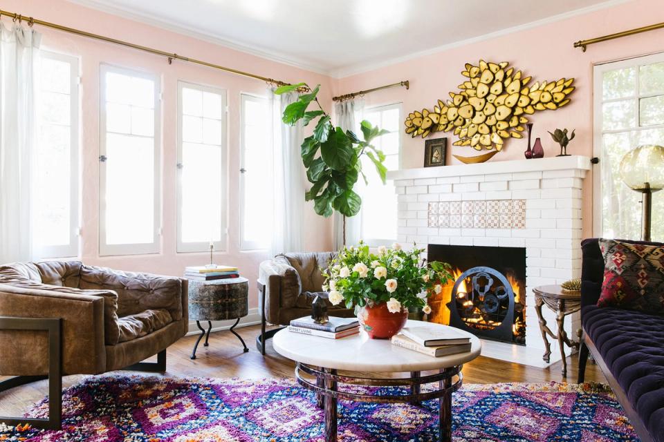 Eclectic living room with blush pink walls, jewel-toned accents, and warm vintage charm