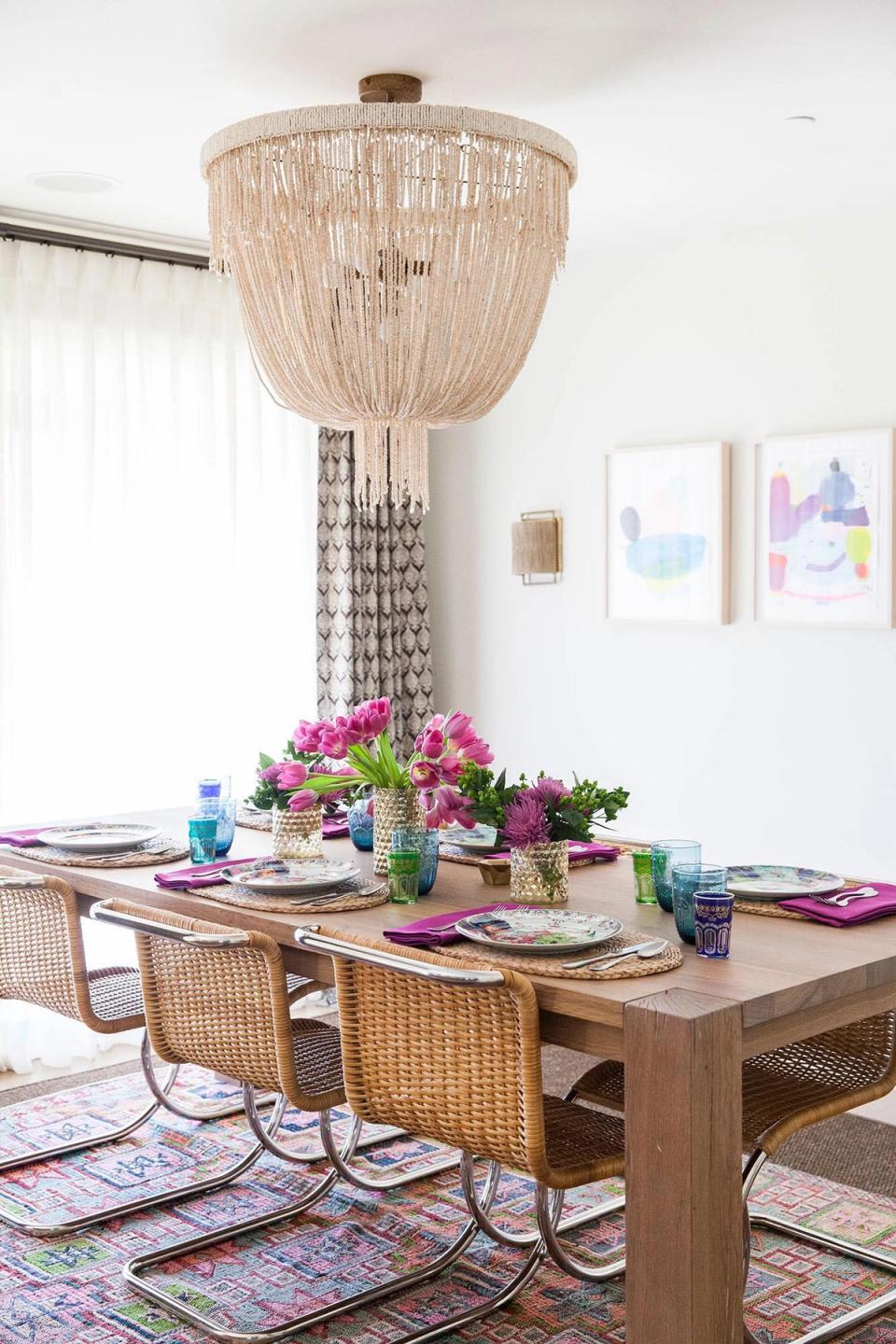 Bohemian dining with beaded chandelier, natural wood table, and vibrant purple accents