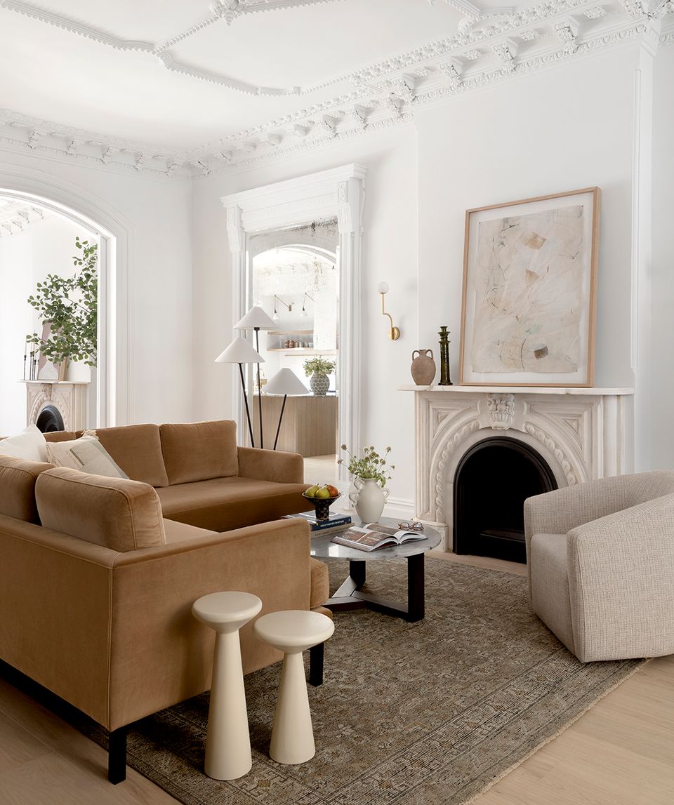 Transitional living room with caramel leather sofa and warm cream fireplace