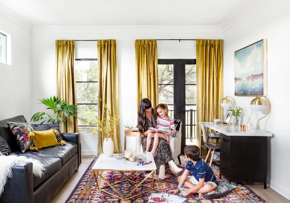 Bright, eclectic learning space with gold curtains, colorful area rug, and mixed seating for family study sessions.