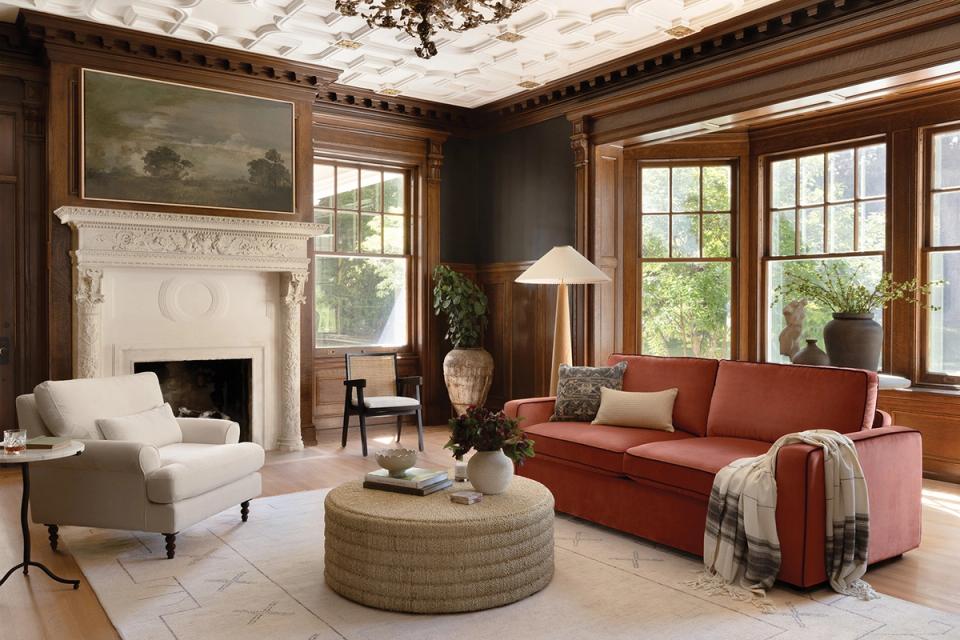 Traditional living room blending dark walls, fireplace, terracotta sofa, and classic wood millwork