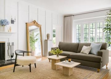 Contemporary living room with sage green sofa, mid-century furniture, and minimalist white shiplap walls