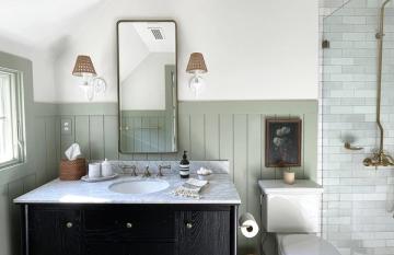 Spa-like bathroom with sage green shiplap wainscoting, black vanity, and classic subway tile