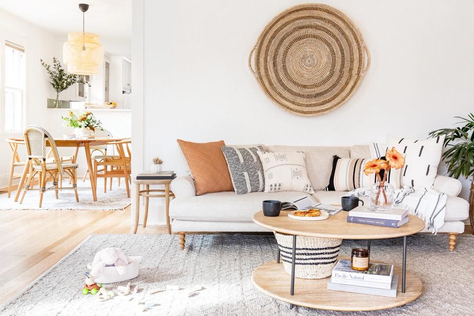 Scandinavian-inspired living room with natural wood accents, woven wall art, cream sofa, and organic textures creating warm, minimalist aesthetic
