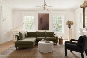 Light-filled living room with wainscoting trim, olive green sectional, picture windows, and timeless neutral palette