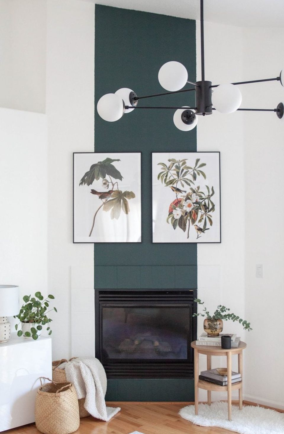 Contemporary accent wall in deep teal with botanical art, sculptural lighting, and organic textures