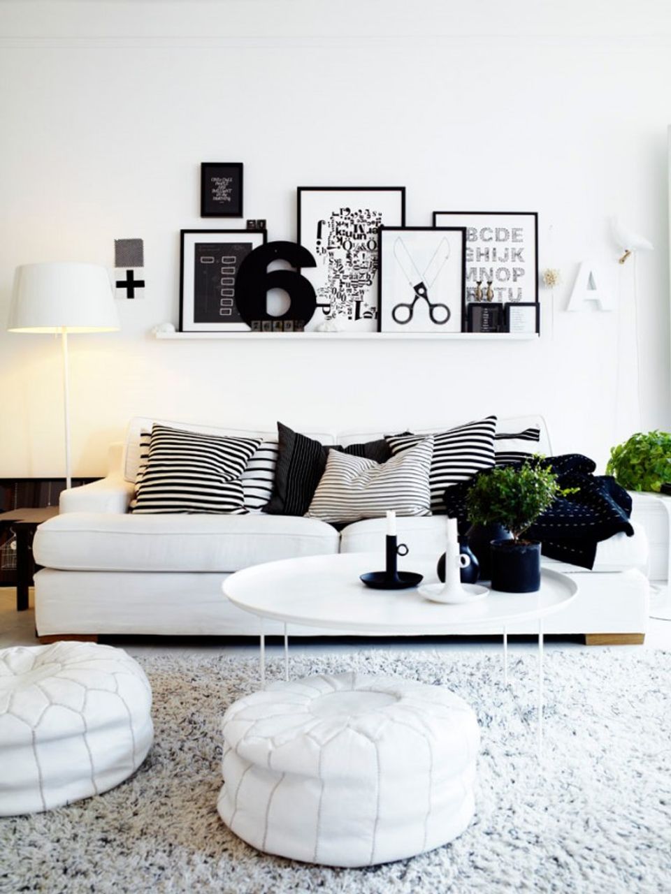 Monochromatic living room in black, white, and cream with curated wall display and modern minimalist styling.