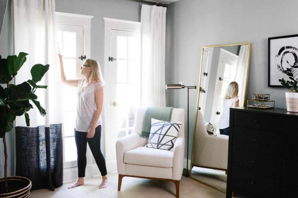 Minimalist black and white bedroom with sheer white curtains filtering natural light through tall windows