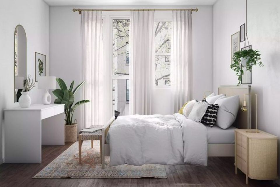 Airy minimalist bedroom with sheer white curtains, light wood nightstands, and plants creating calm atmosphere
