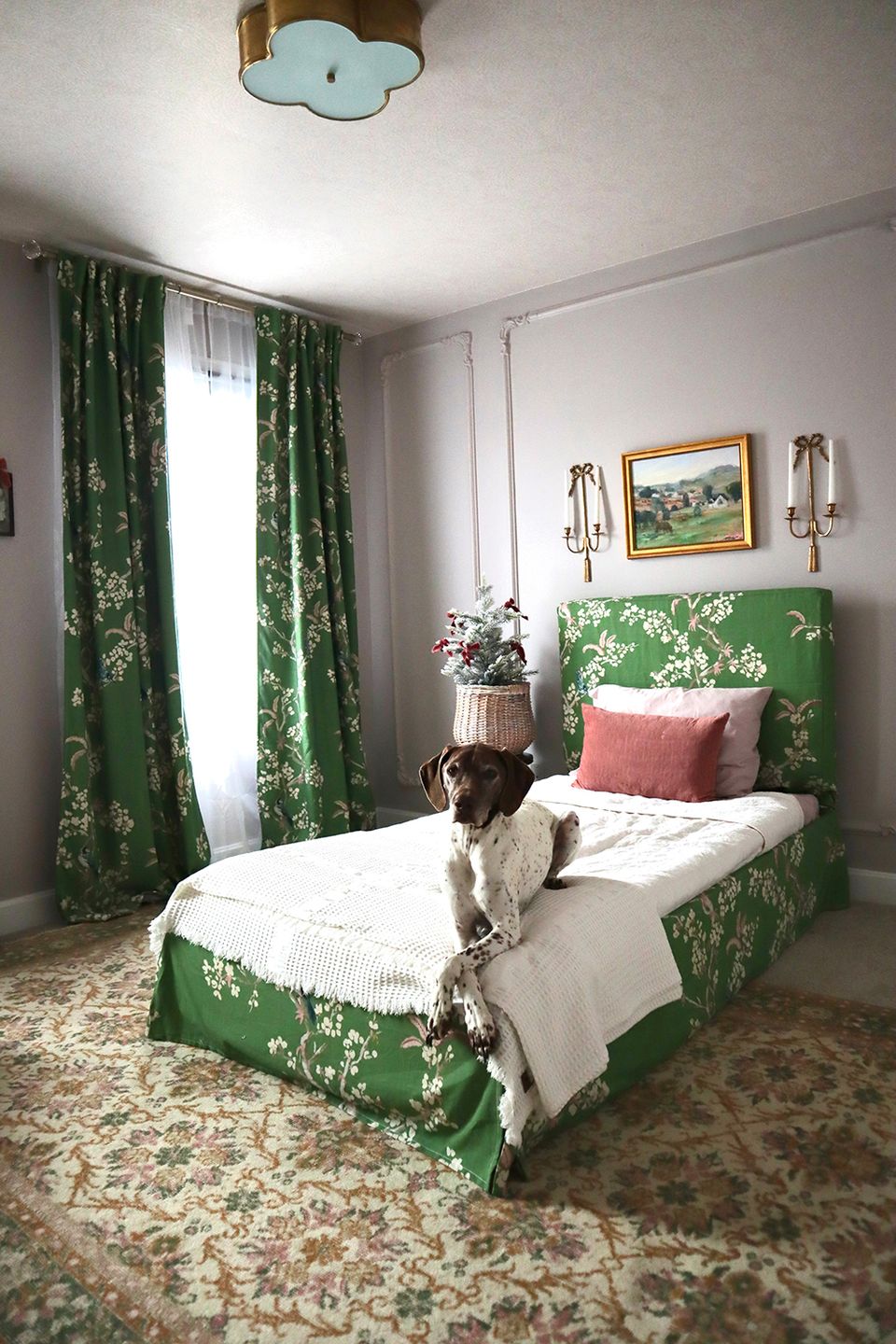 Botanical maximalist bedroom with emerald floral bedframe, green curtains, and vintage touches