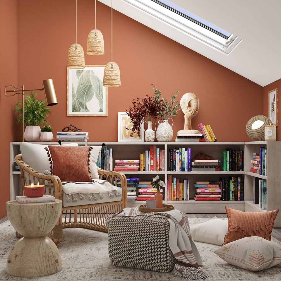 Warm terracotta accent wall creates a bold, inviting nook with woven textures, layered lighting, and earthy bohemian charm.