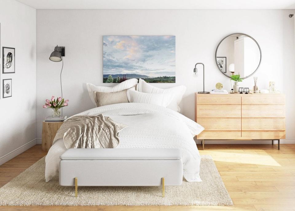 Serene minimalist bedroom with natural wood furniture, soft neutral palette, and landscape artwork creating a calm, eco-conscious retreat.