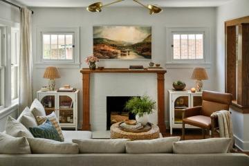 Traditional living room with a neutral sofa, a fireplace, and framed landscape art