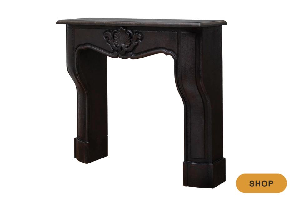 Ornate black faux fireplace mantel with classical architectural detailing