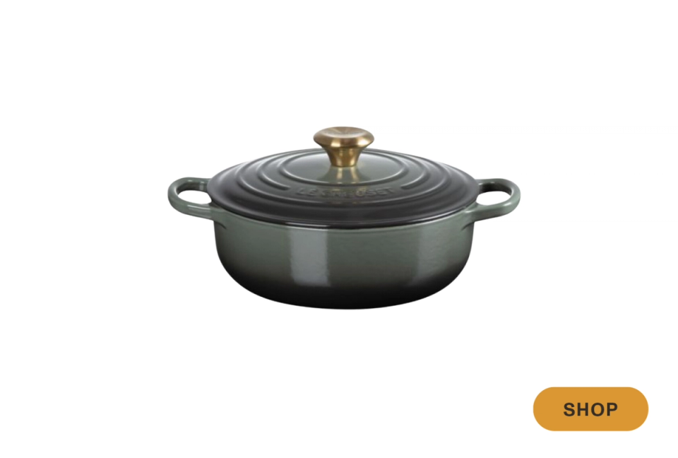 Modern dark green enameled cast iron Dutch oven with brass accents