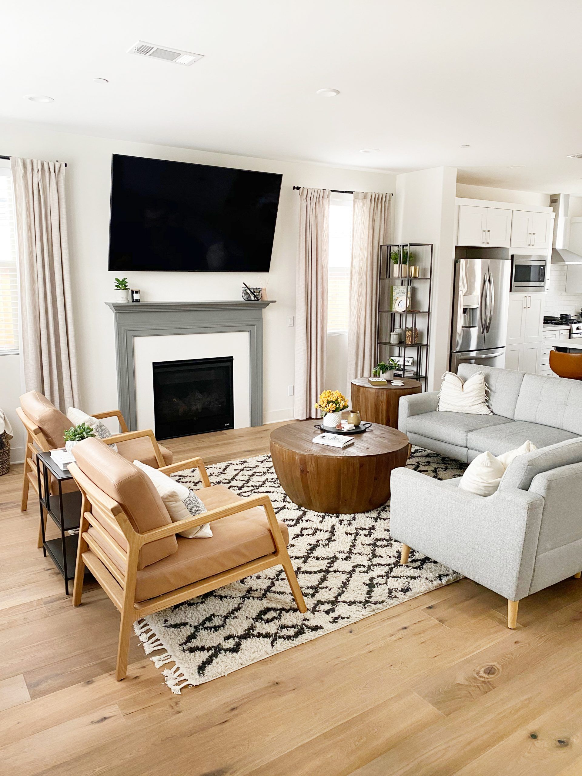 Bright mid-century modern living room with warm wood tones, cream upholstery, and geometric accents creating a balanced, inviting atmosphere.