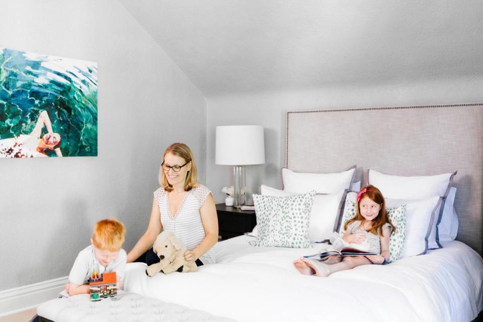 Bright, minimalist kids' bedroom with coastal artwork, neutral palette, and clean white bedding creating a calm, playful atmosphere.
