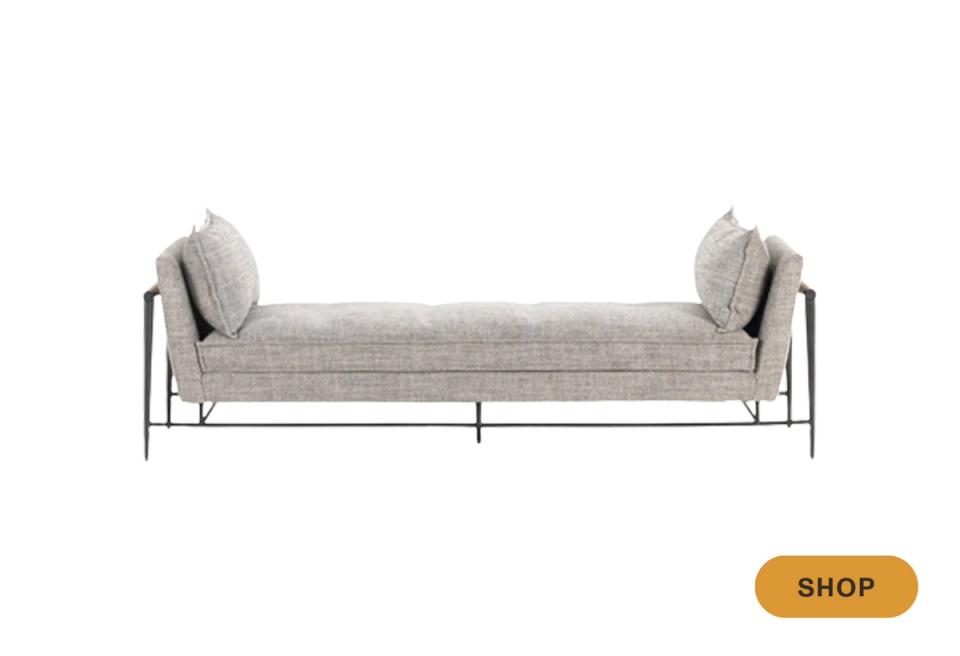 Industrial-style daybed featuring steel frame with cream linen upholstery and minimalist pillow accents.
