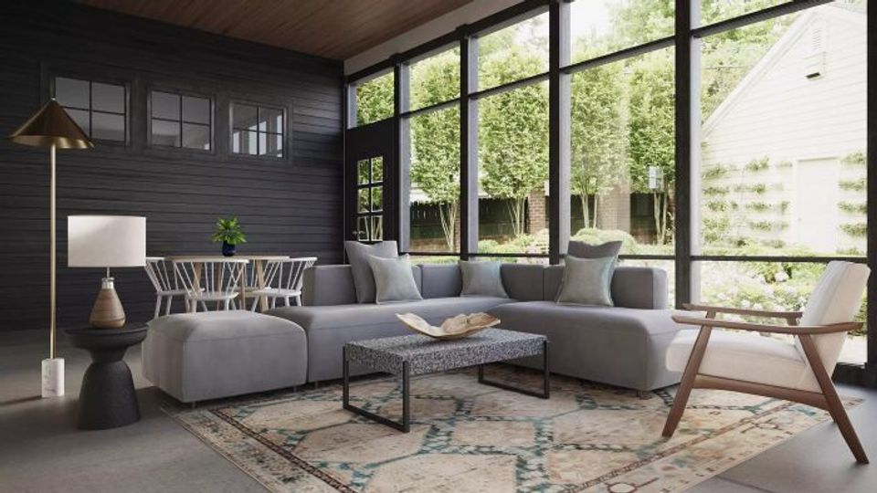Scandinavian-inspired sunroom with dark charcoal walls, floor-to-ceiling windows, gray upholstery, and natural wood creating serene modern retreat.