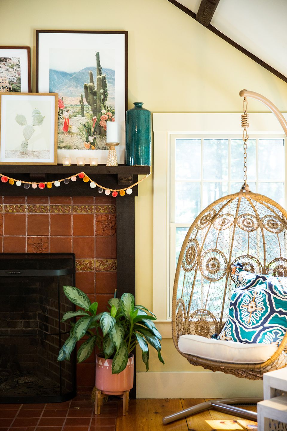 Bohemian reading retreat with warm yellow walls, terra cotta tones, and rattan hanging chair