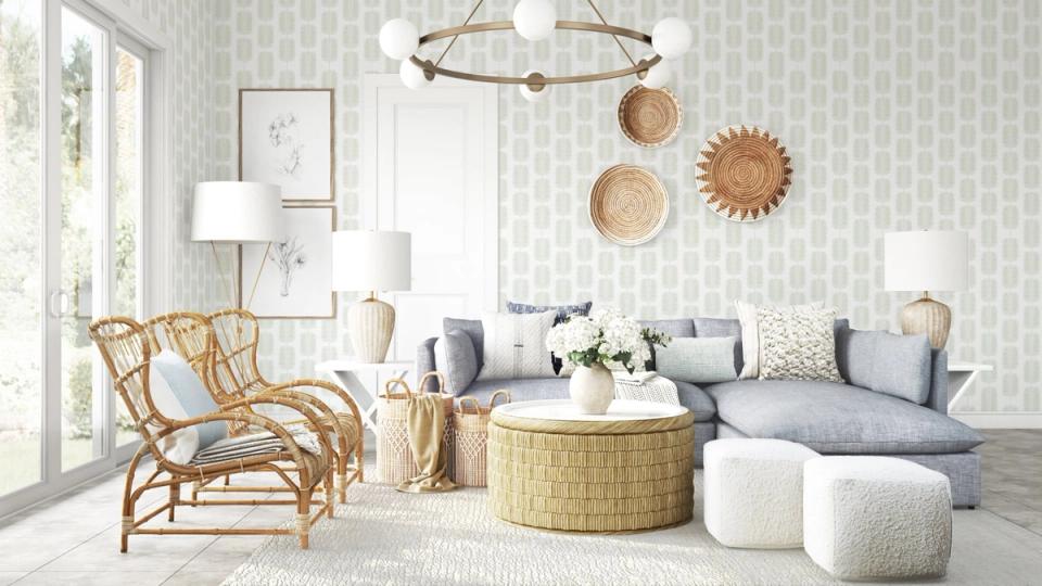 Airy coastal living room with woven accents, soft blue-gray palette, natural light, and geometric wallpaper.