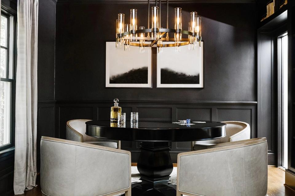 Modern sophisticated office with black walls, brass lighting, and neutral seating