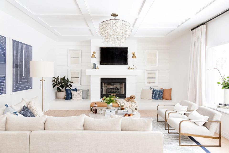 Serene modern living room with white palette, fireplace surround, soft neutral furnishings, and minimalist aesthetic