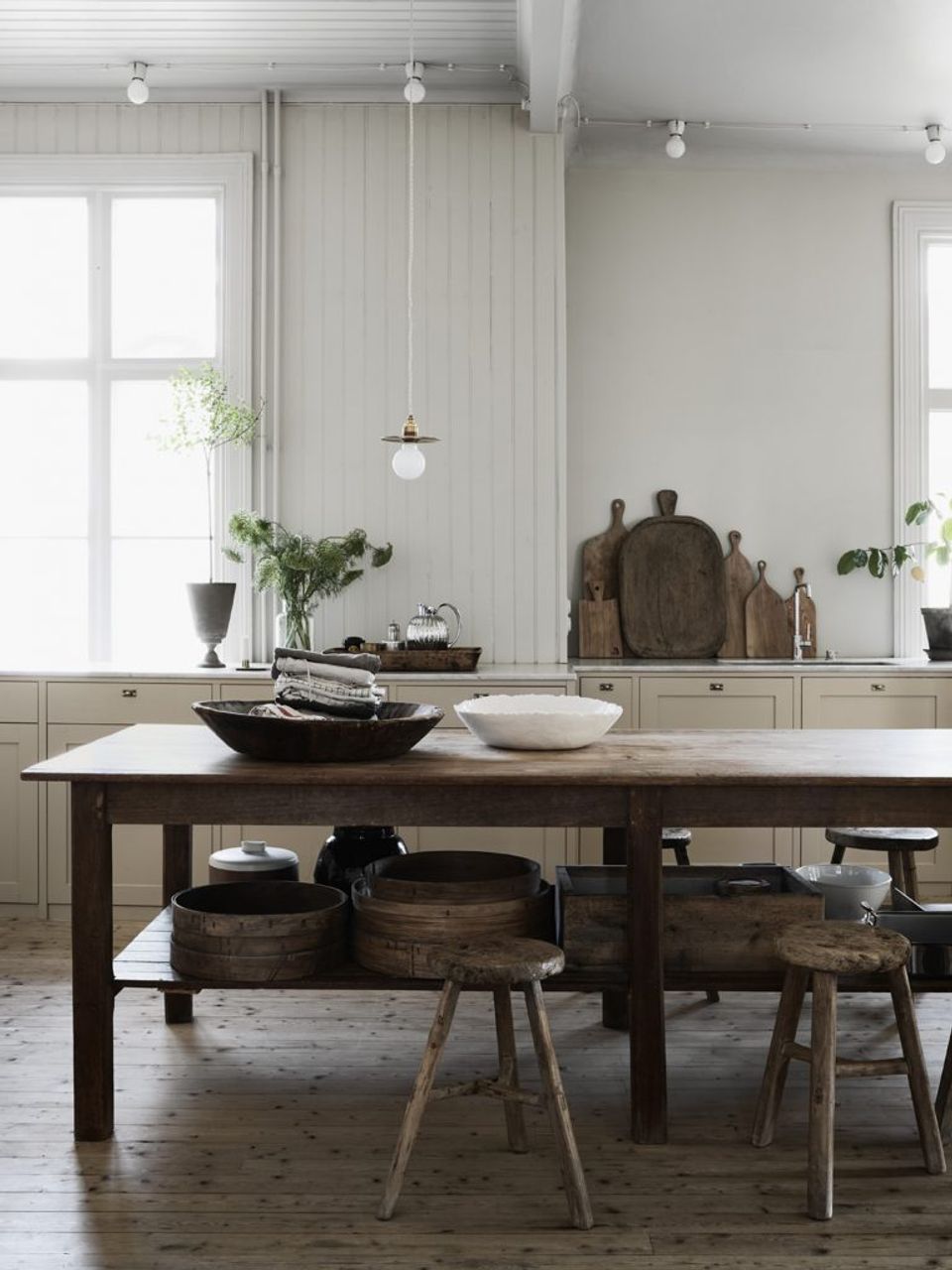 Scandinavian-inspired dining space with vertical shiplap, dark wood table, and pendant lighting