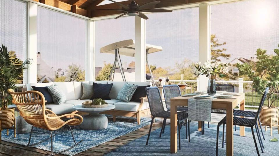 Contemporary outdoor living room with modern seating, teal rug, and floor-to-ceiling windows