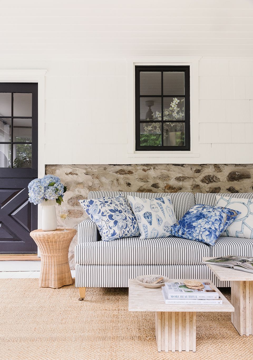 Coastal farmhouse living area with striped sofa, blue and white accents, and natural textures