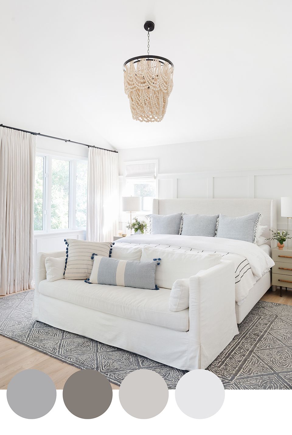 Coastal contemporary bedroom in soft whites and grays with natural woven pendant light and layered textiles evoking peaceful simplicity.