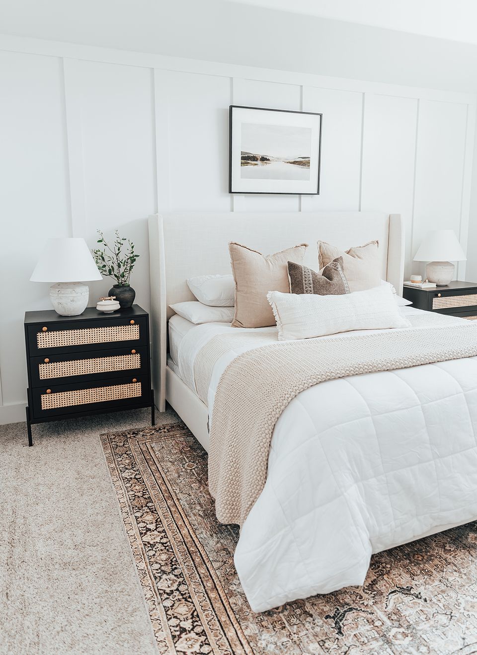 Scandinavian-inspired bedroom: white shiplap headboard, black rattan nightstand, neutral tones, minimalist