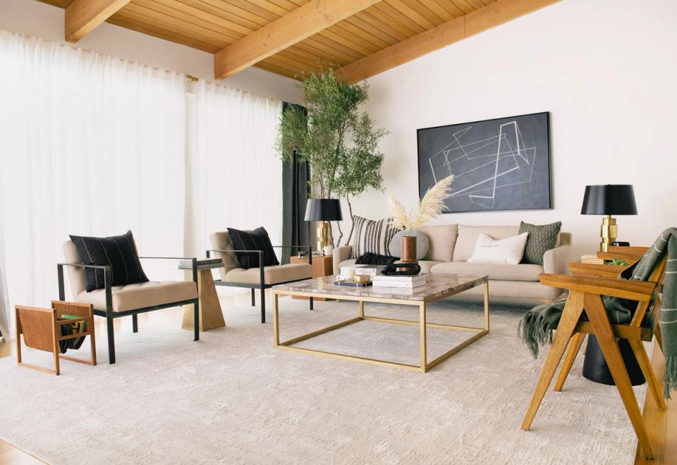 Minimalist wabi-sabi living room with warm wood beams, neutral palette, natural greenery, and simple mid-century furniture creating serene, organic atmosphere.