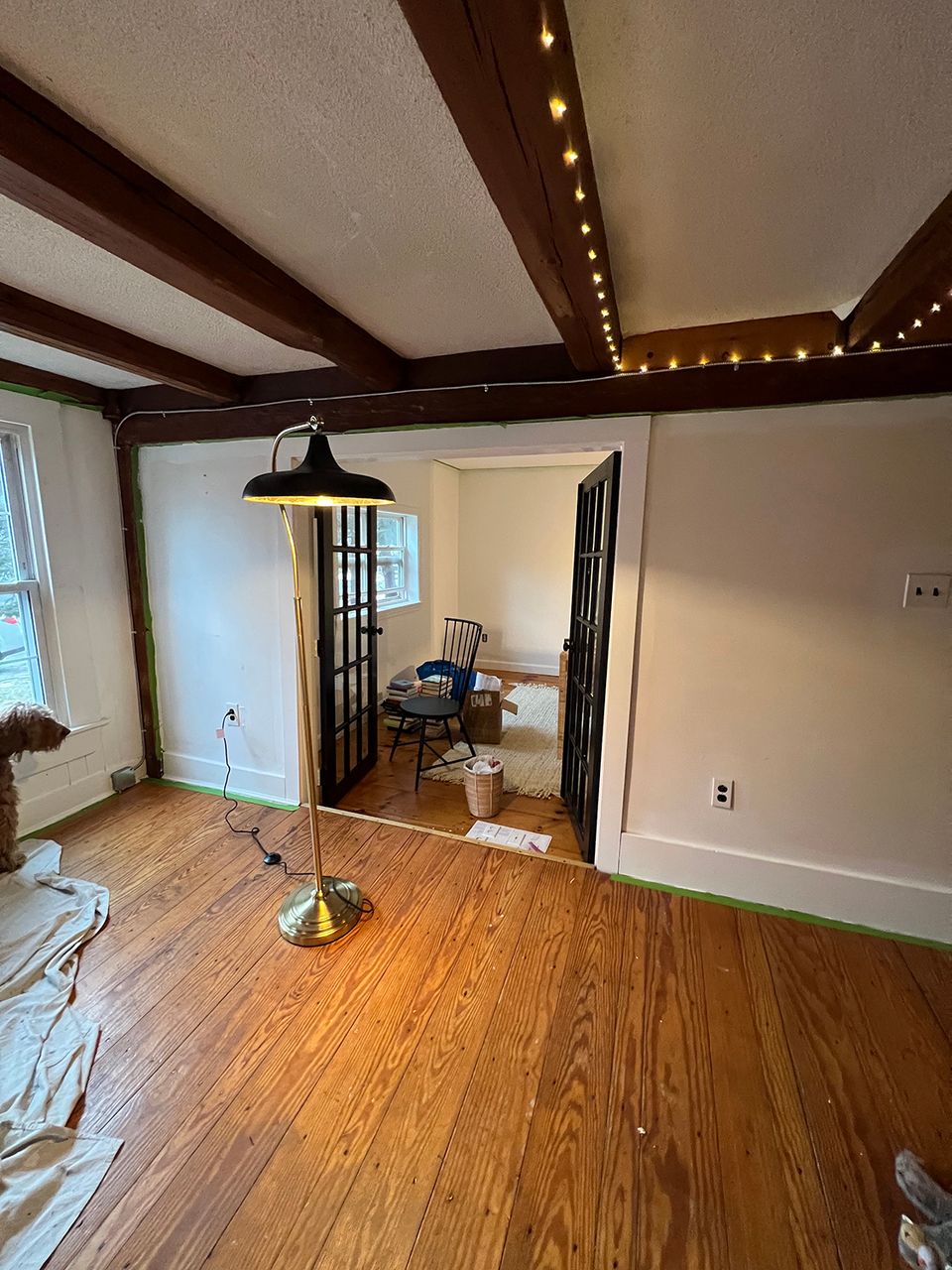 Industrial-transitional space with dramatic dark beam ceiling, warm wood floors, and contemporary fixtures