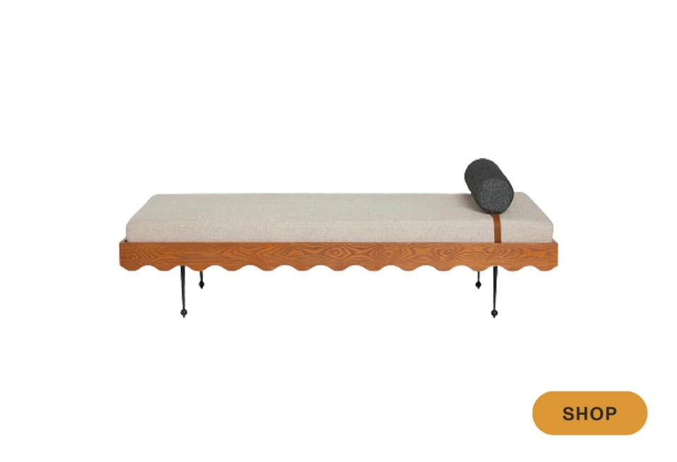 Eclectic daybed featuring scalloped wood frame trim, minimal mattress, and playful retro charm.