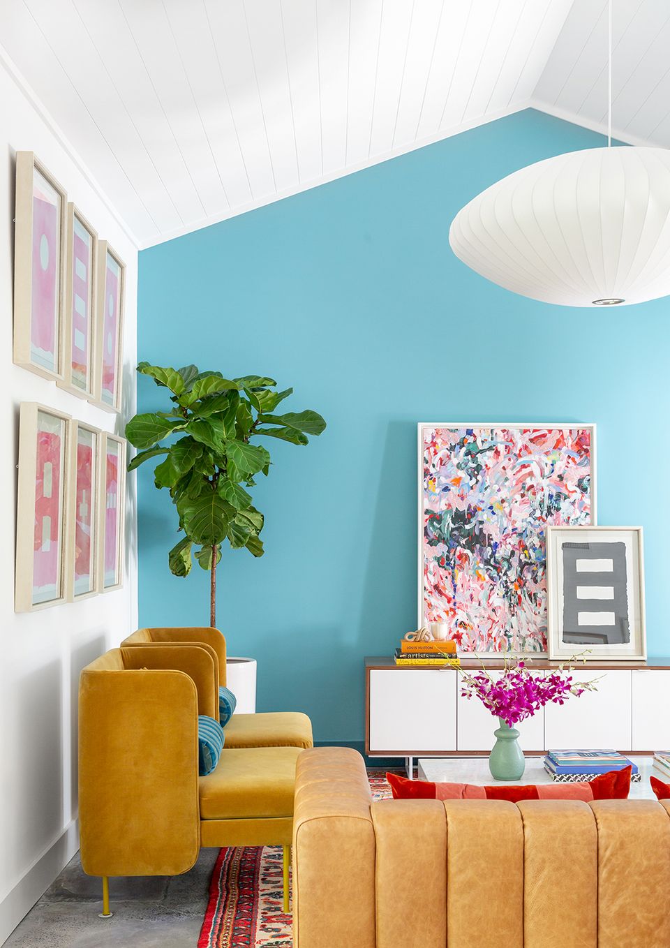 Eclectic bedroom nook with bold turquoise matte wall, mustard velvet chair, and vibrant gallery wall accent