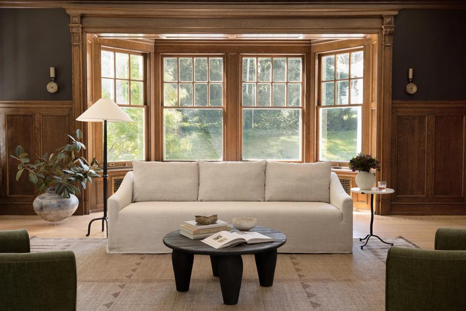 Sophisticated room with rich wood paneling, cream sofa, and neutral tones creating warm, timeless appeal