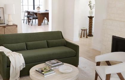 Modern living room with sage green sofa, light wood coffee table, and minimalist Scandinavian aesthetic
