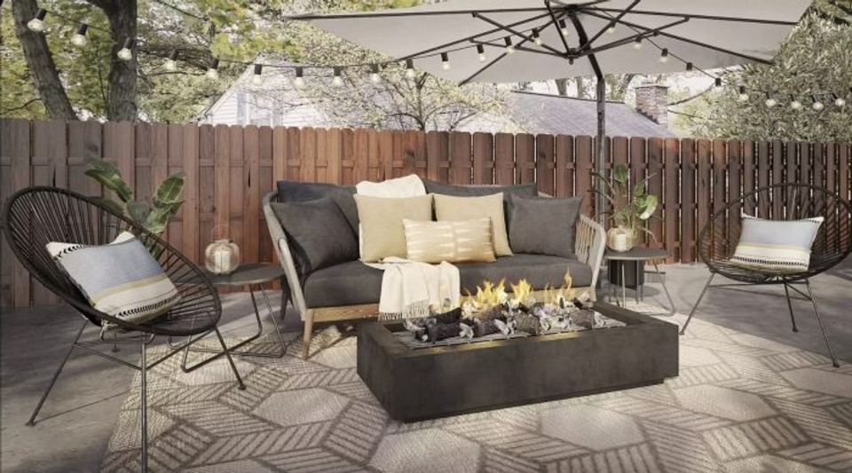 Contemporary patio with dark fire pit, cream seating, and geometric patterned rug