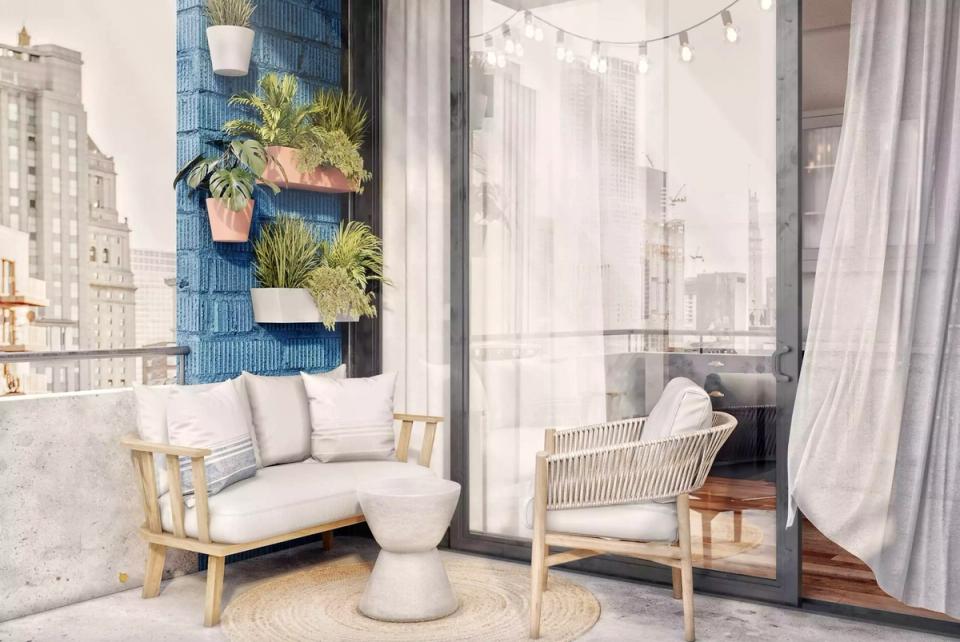 Minimalist urban balcony with blue living wall, white seating, and sheer curtains