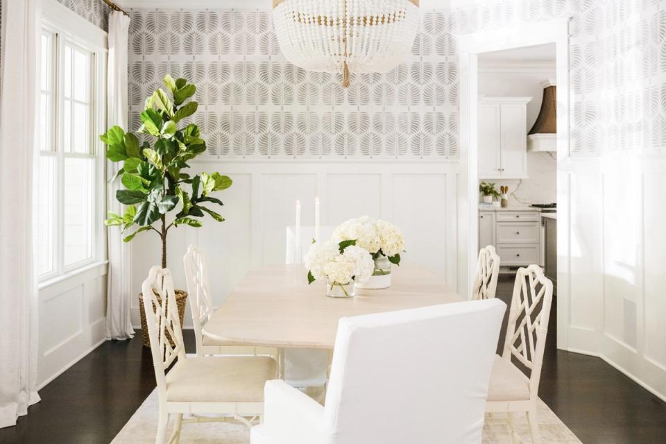 Sophisticated white dining room with patterned wallpaper, greenery, and coastal-inspired aesthetic