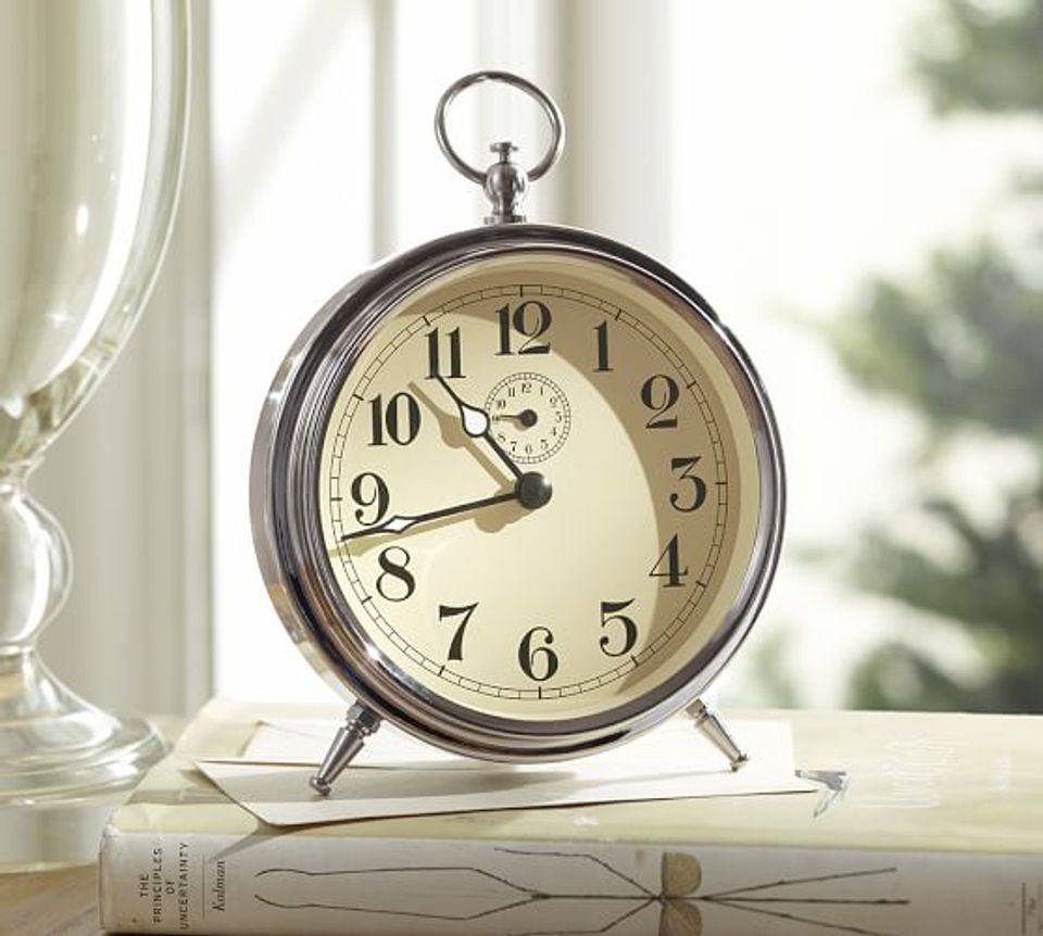 Vintage-style chrome alarm clock with cream dial on bright windowsill, creating a classic, optimistic morning mood