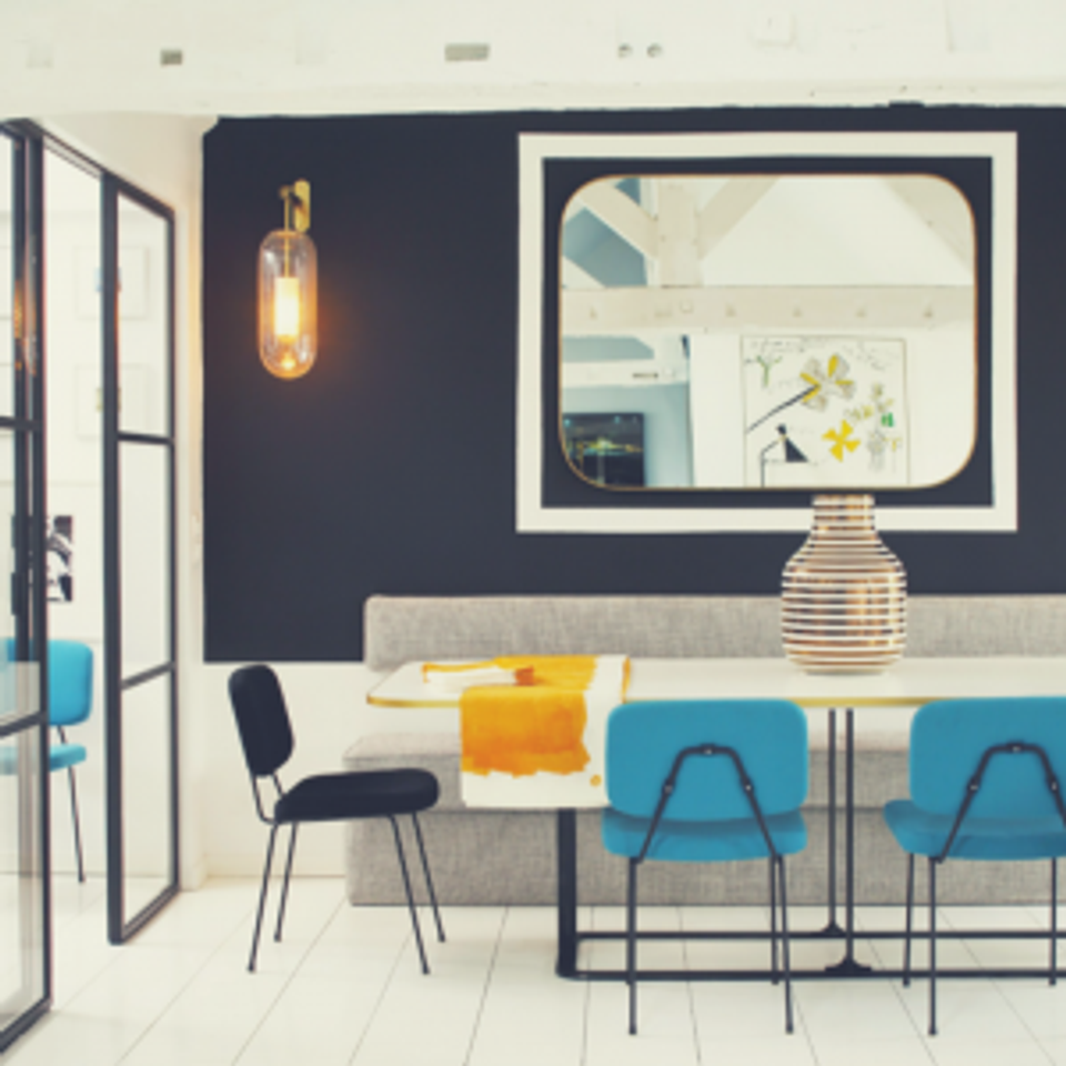 Modern dining space with dark accent wall, brass pendant sconce, and turquoise chairs creating contemporary contrast