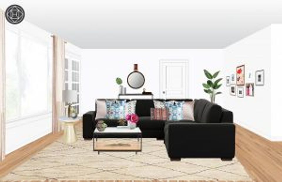 Modern living room with black sectional, neutral rug, wooden floors, and curated gallery wall