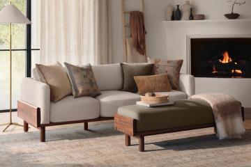 Warm transitional living room with neutral sofa and patterned throw pillows by fireplace