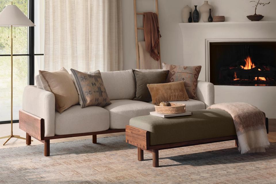 Warm transitional living room with neutral sofa and patterned throw pillows by fireplace