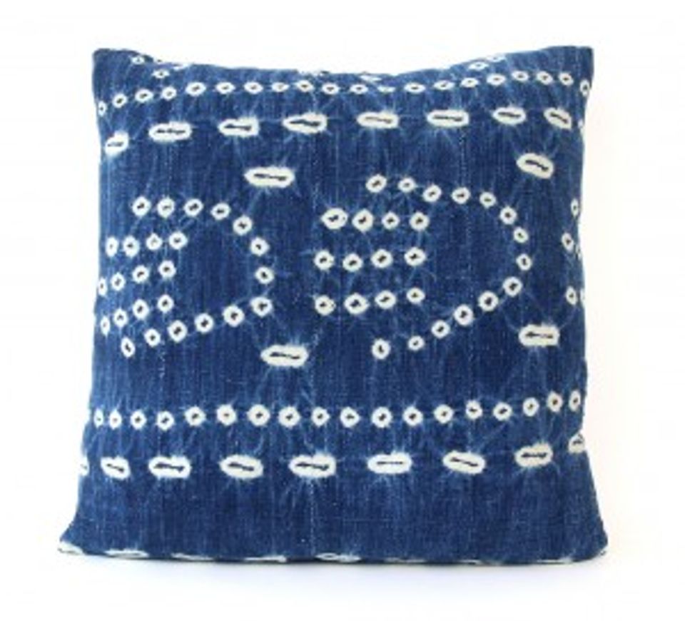 Deep blue pillow with white boat and dot motifs reflecting nautical tradition