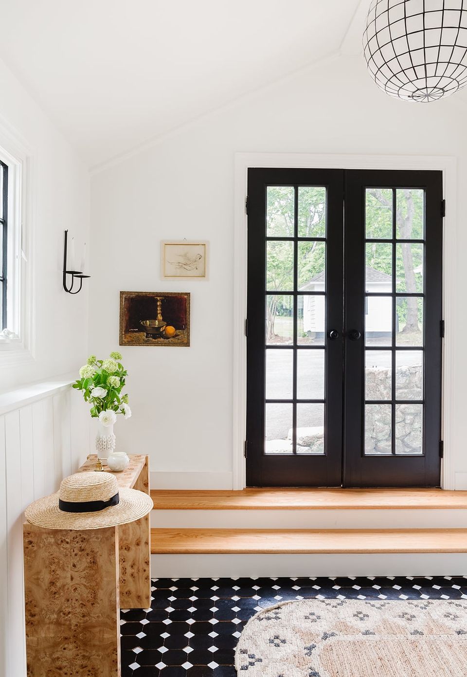 Minimalist entryway with black geometric patterned runner rug and neutral palette accented by dark architectural doors