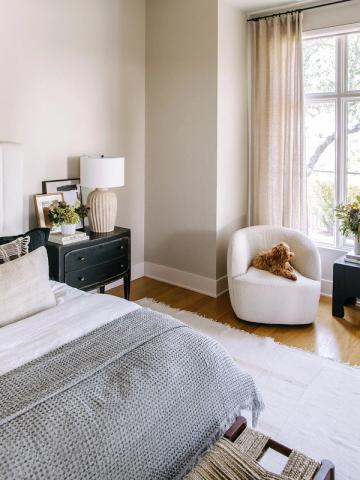 Modern bedroom with gray accent wall, black nightstand, and soft earth tones